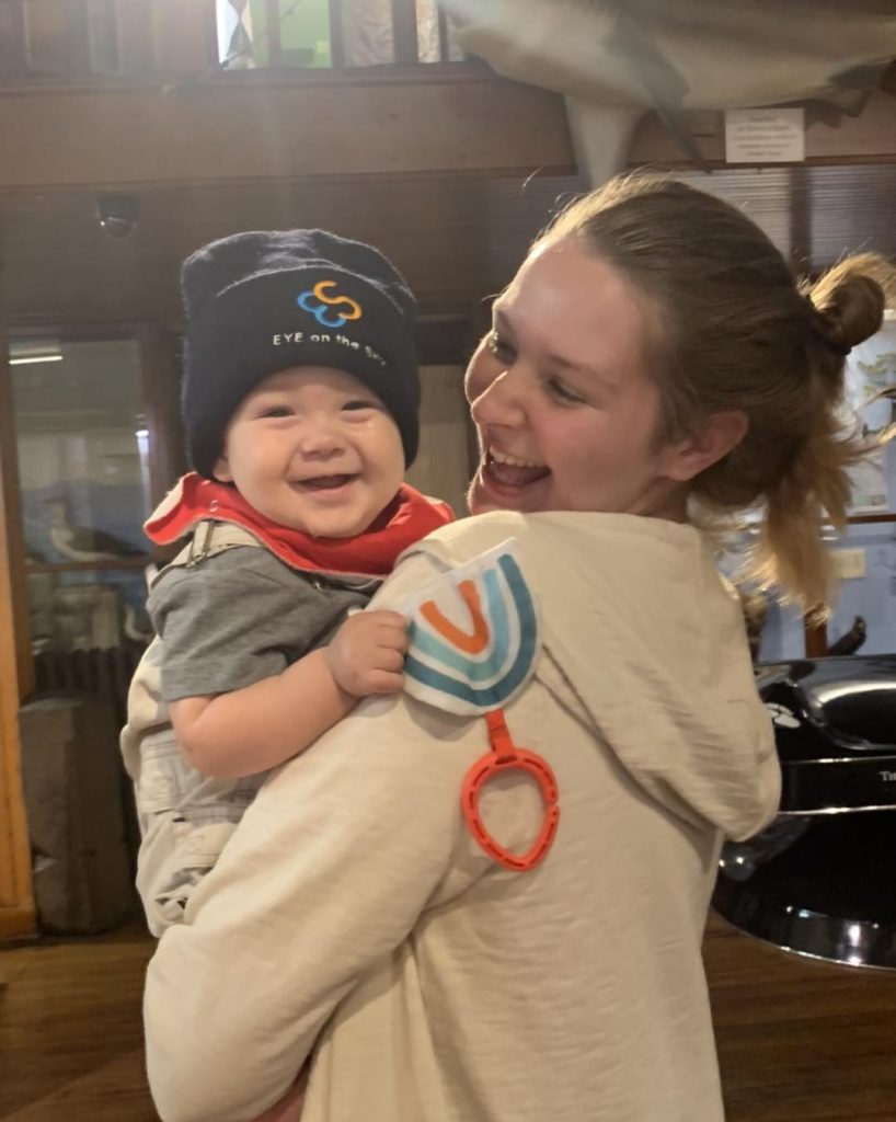 smiling baby wearing an eye on the sky hat
